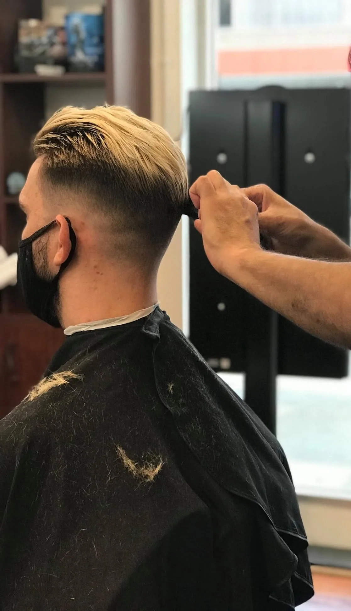 Finished skin fade and clean neckline, barber's comb in hair