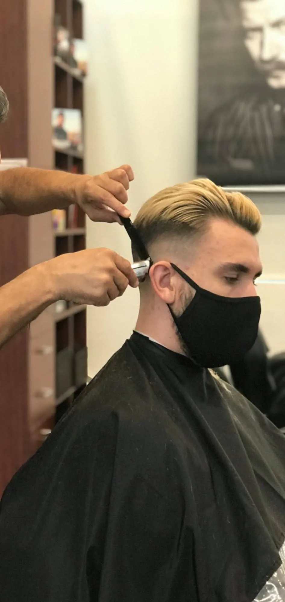 Barber clipper-lining the nape of a client