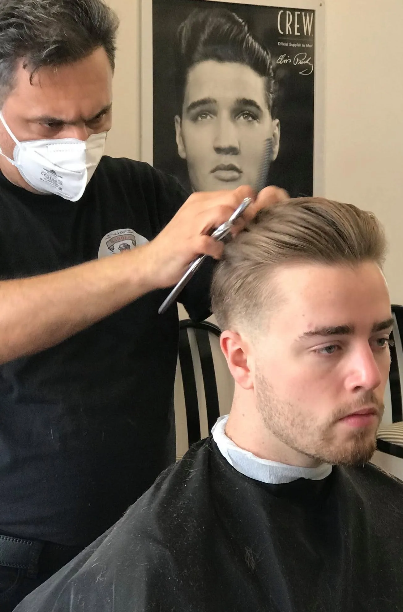 Barber scissor-cutting a client's top, craft in action